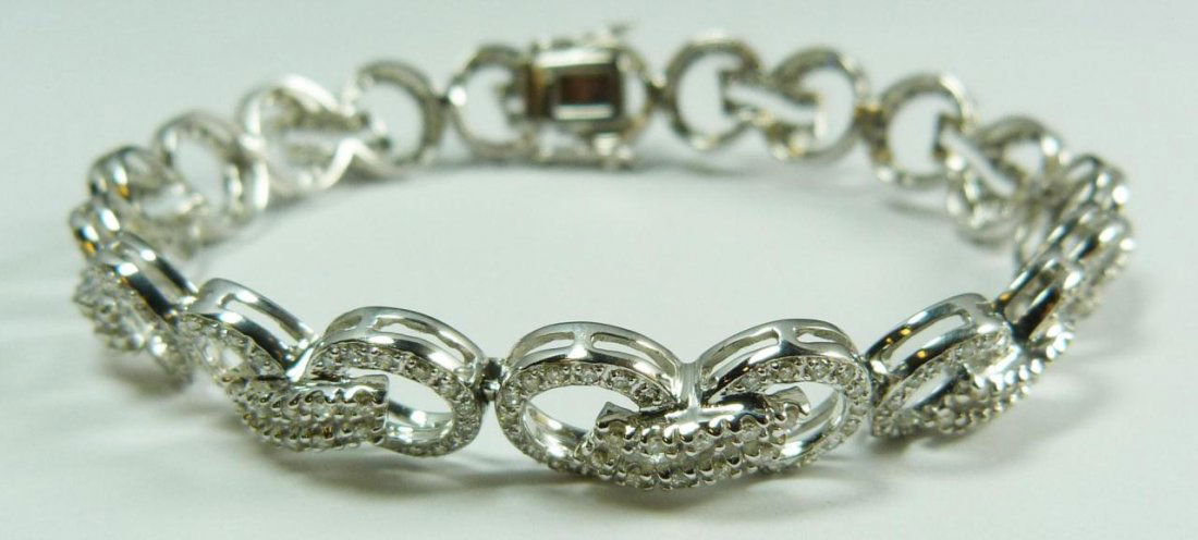 A 14K WHITE GOLD AND DIAMOND BRACELET: A stunning ladies 14k white gold bracelet having a double O link design and set with approx. 440 diamonds approx. 4.40ctw. Measures 6 7/8" length (17.4cm). Measures 10mm width. Total weight of 10.3dwt