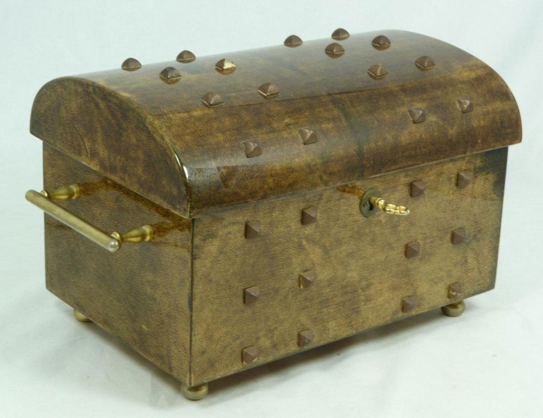 ALDO TURA ITALIAN LACQUERED GOATSKIN JEWELRY BOX: An Aldo Tura Italian lacquered goatskin jewelry box having bronze mounted spikes to exterior. Gilded brass handles to sides. Four beaded feet. Locking mechanism to front with original key. Gold velour
