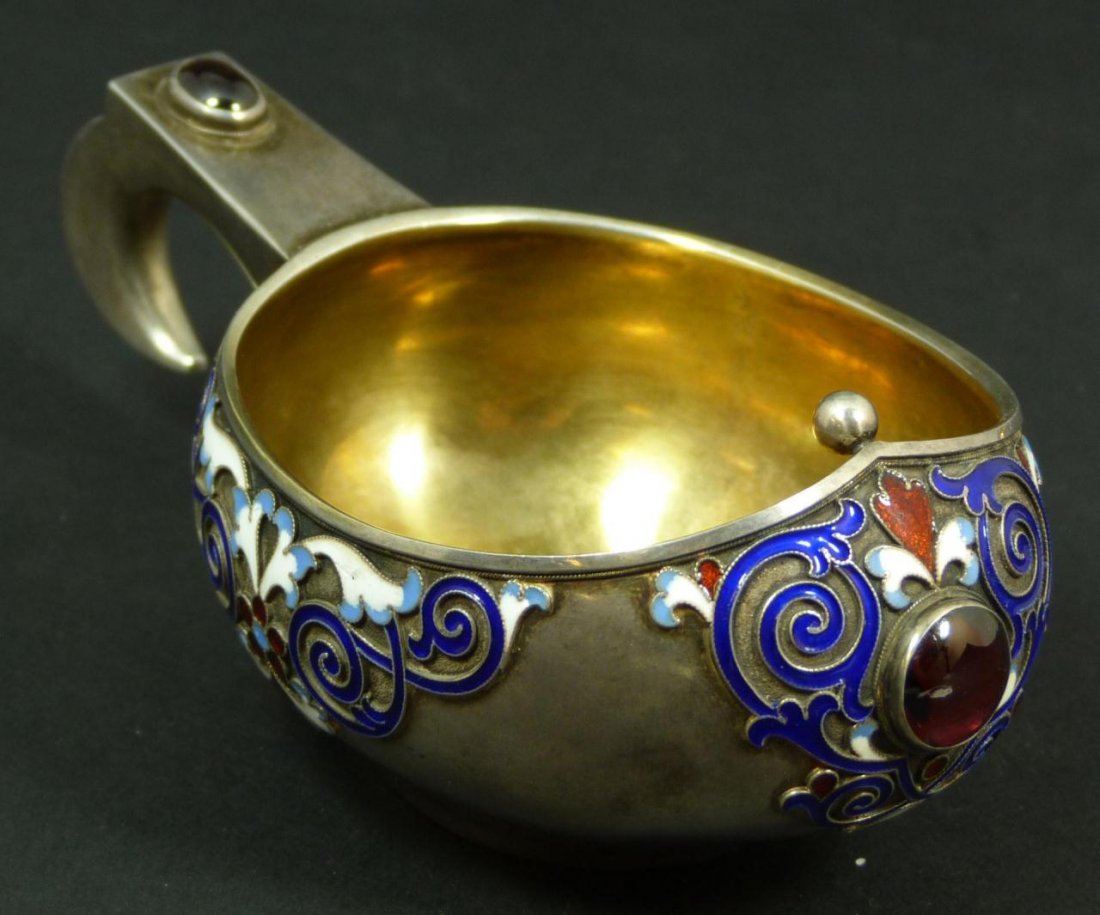 RUSSIAN ENAMELED SILVER JEWELED FLORAL KOVSH: Russian silver jeweled kovsh. Decorated to sides with enameled scrolled design. Mounted cabochon rubies to front and handle. Gold wash Interior. Holds Double Headed eagle mark with work master hallmar