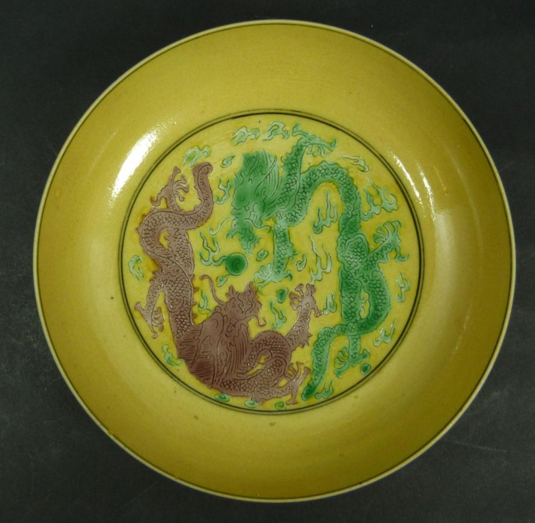 18th C YELLOW GROUND GREEN GLAZE DRAGON DISH: An antique Chinese Qind Dynasty period dish depicting a green and purple dragon flying amongst flames with dragon jewel. Exterior decorated with grape clusters and leaves. Bottom holds black six chara