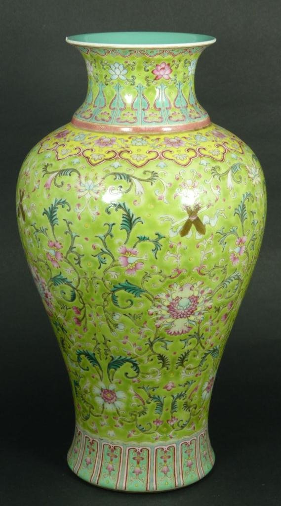 18th C CHINESE FAMILLE ROSE PORCELAIN VASE: An antque Chinese Qing Dynasty period famille rose enameled hand painted porcelain mei ping form vase with flared lip. Has floral design throughout with scrolled leaves and vines over green ground. Ho