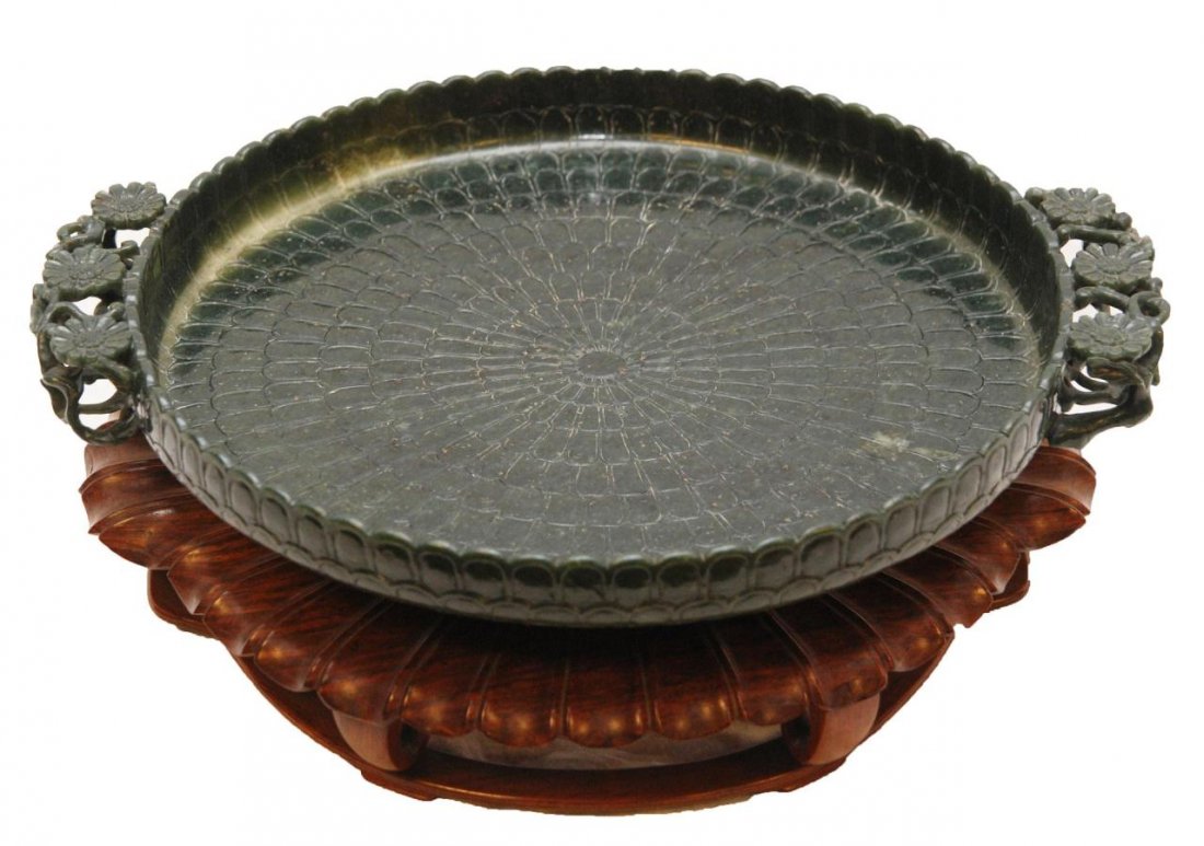 SPINACH GREEN JADE MUGHAL STYLE FLORIFORM BOWL: Chinese carved spinach green jade Mughal style floriform handled bowl. Of shallow circular form with straight sides. Carved with a pattern of overlapping concentric petals. Openwork floriform handles.