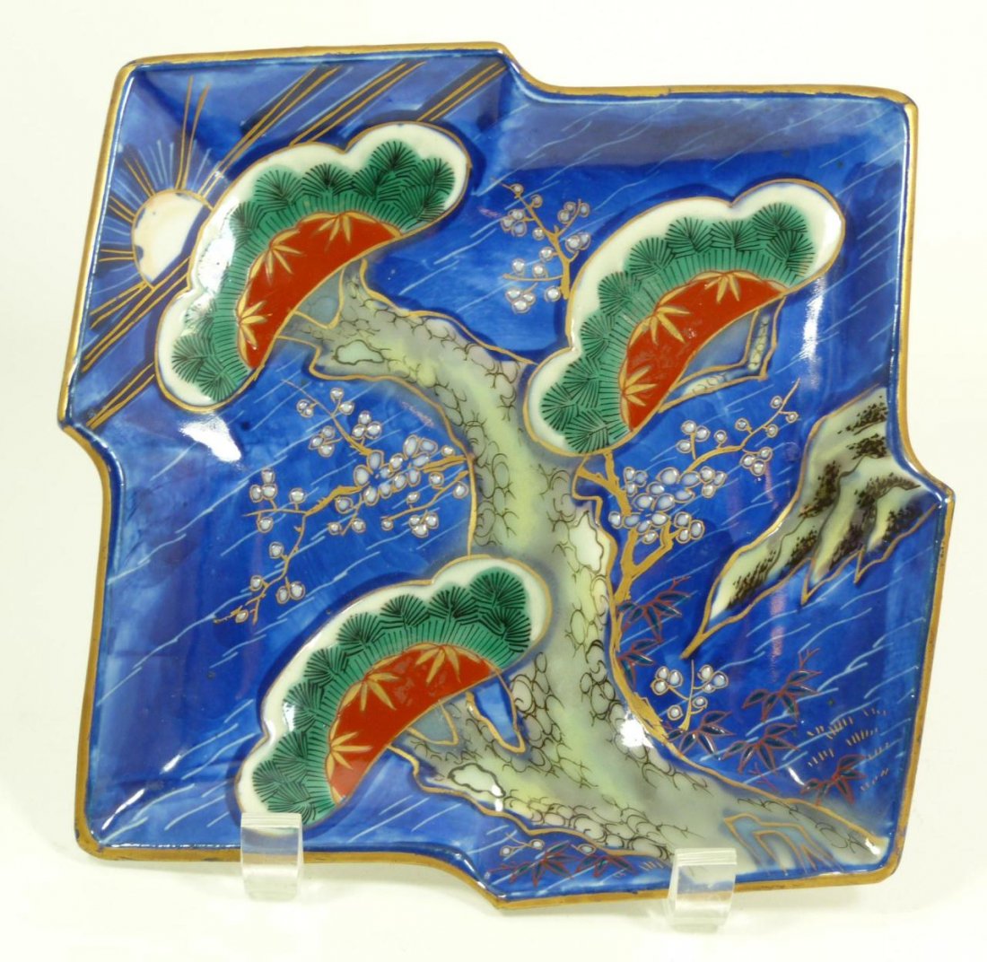 JAPANESE PORCELAIN ENAMELED IMARI PLATE: Antique Japanese hand painted and enameled Imari plate. Depicts pine tree with flowers and rock formation. The sun can be seen in the background. Verso depicts blue flowers. Bottom holds calligraphy m