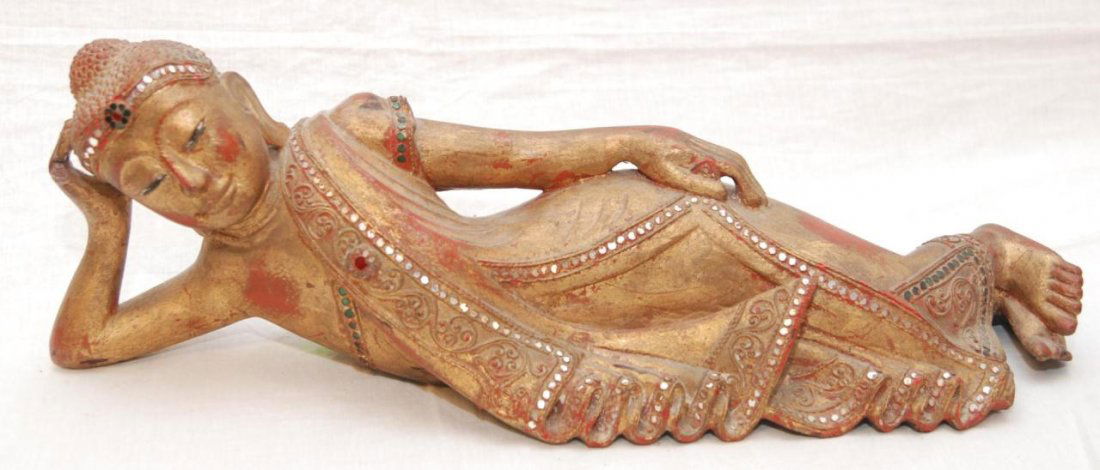 18th CENTURY PARINIRVANA THAI BUDDHA SCULPTURE: Antique Thai gilded wooden sculpture depicting Buddha attaining Parinirvana. Jeweled with stones and enamels. Circa late Kingdom of Ayutthaya to early Rattanakosin Period. Measures 6 3/8" height x 21"
