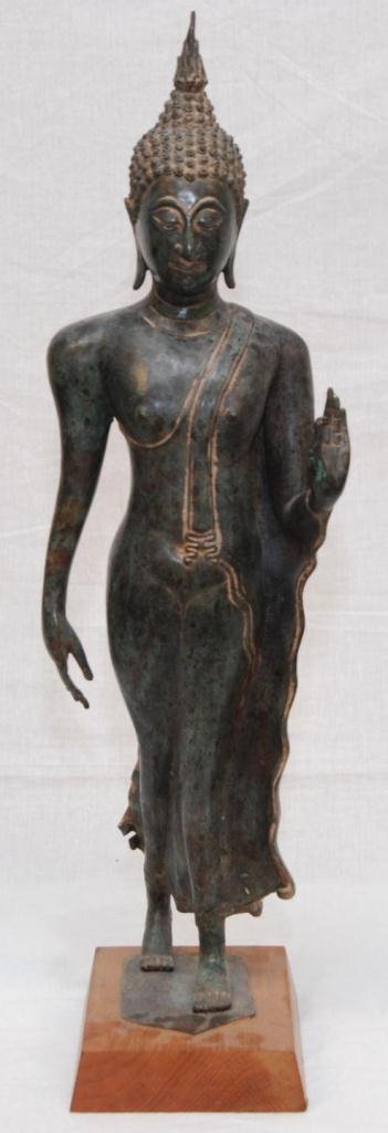 18th CENTURY THAI WALKING BUDDHA FIGURE: An antique Thai walking Buddha. Mounted on wooden base. Circa late Ayutthaya to Rattanakosin period. Measures 25" height + 1 1/2" base height (63.5cm + 3.8cm). Total weight of 6.34 kilograms.