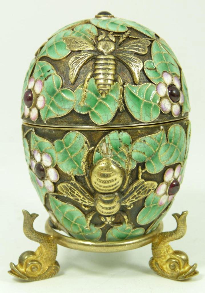 RUSSIAN SILVER ENAMELED FLIES EGG WITH STAND: Russian silver enameled egg box having floral design throughout with raised gold wash flies and bees. Has 8 cabochon cut rubies set throughout. Gold wash interior. Holds Cyrillic Pavel Akimov Ovchinni