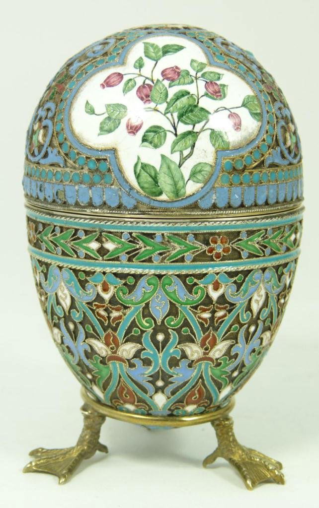 RUSSIAN SILVER ENAMELED FLORAL EGG: Russian silver enameled egg box having two floral miniatures. Gold wash interior. Includes stand with three figural duck form feet. Piece holds Cyrillic Pavel Akimov Ovchinnikov workmaster marks. Hold
