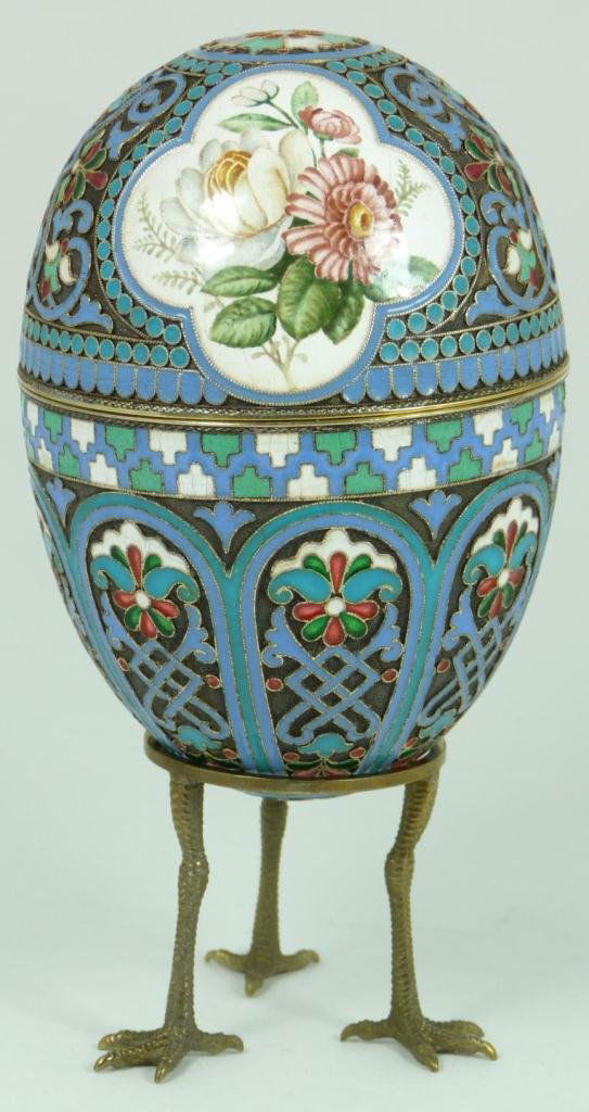 RUSSIAN SILVER ENAMELED FLORAL EGG: Russian silver enameled egg box having two floral miniatures. Gold wash interior. Includes stand with three figural eagle feet. Piece holds Cyrillic Pavel Akimov Ovchinnikov workmaster marks. Holds 88