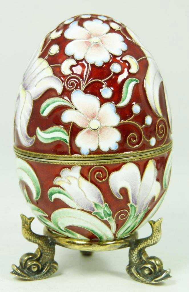 RUSSIAN ENAMELED SILVER FLORAL EGG: Incredible Russian silver egg. Has beautiful enamel floral design over rust ground. Gold wash interior. Has workmaster mark and 88 silver purity mark. Has silver footed stand with figural fish design.