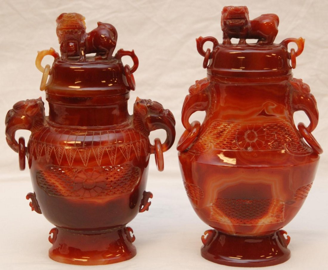 PAIR OF CHINESE AGATE CEREMONIAL FOO DOG URNS: Pair of Chinese carved agate ceremonial foo dog urns. Each having figural foo dog finial to cover. Bodies holding a raised Chih Lung Dragon design. Reticulated screen design to necks. Figural beast ha