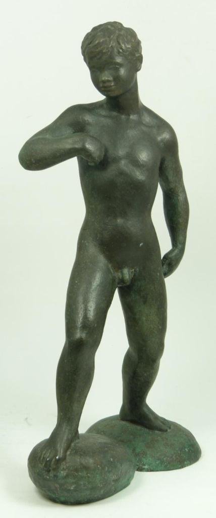 BRONZE STATUE DEPICTING A STANDING NUDE BOY: Bronze sculpture depicting a standing nude boy on two rounded stones. Measures 15 7/8" height (40.3cm). Total weight of 3343 grams. Provenance: Sam Feldman Collection.