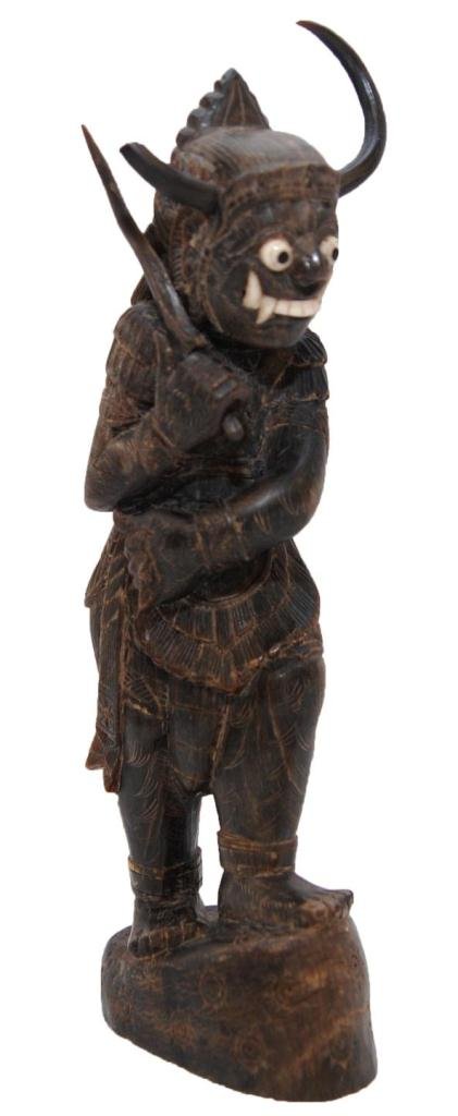 BALINESE CARVED RHINO HORN FIGURE OF WARRIOR GOD: An antique Balinese carved rhino horn figure depicting a warrior god holding a sword in right hand. Has ivory inlay eyes and teeth. Measures 7 5/8" height (19.3cm). Total weight of 239 grams.