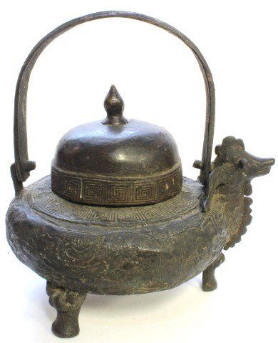 CHINESE SUNG DYNASTY BRONZE RITUAL VESSEL: Antique Chinese bronze Sung Dynasty handled tripod ritual vessel with figural beast design and raised Etruscan pattern throughout. Pointed spire on dome cover. Measures 7 1/2 height x 7" width x 6 1/2
