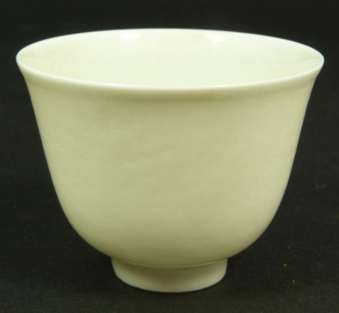 18th/19th C CHINESE EMBOSSED WHITE EGG SHELL CUP: 18th/19th c Chinese embossed white tea bowl with scrolled dragon design on exterior. Has calligraphy mark to bottom. Measures 5cm height. Weight 24g.