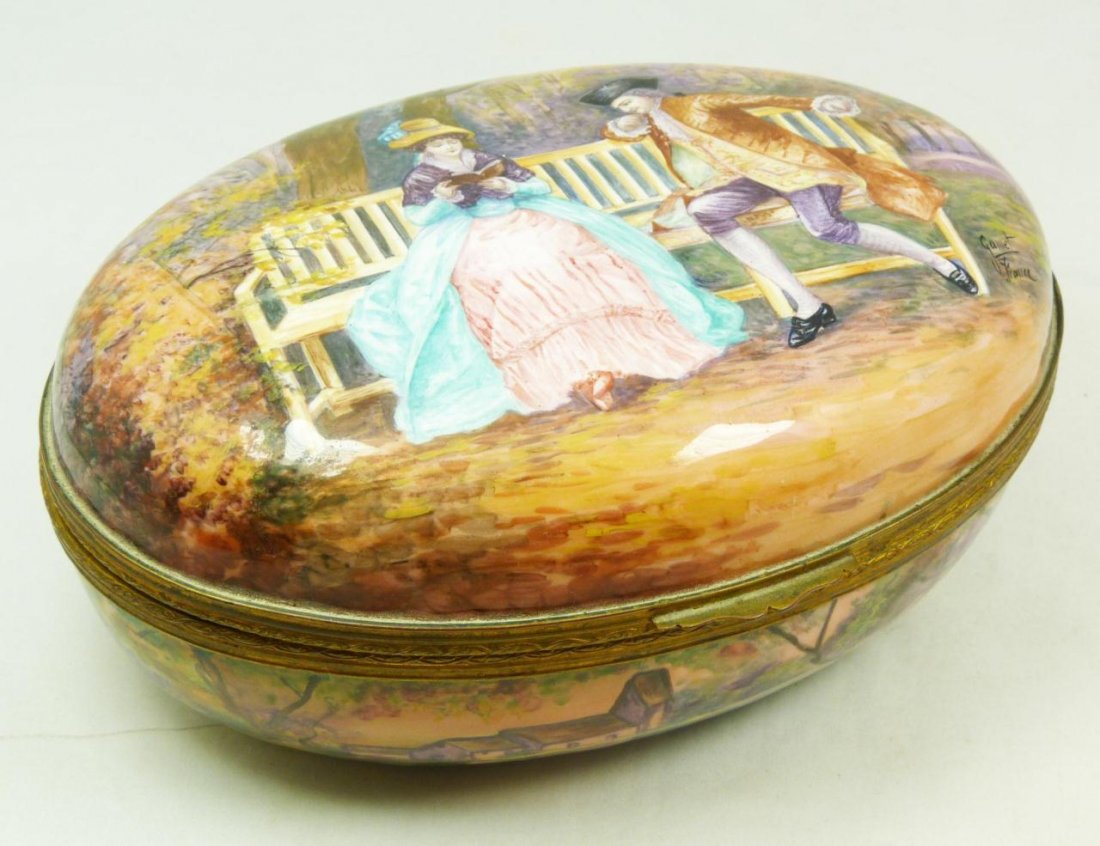 ANTIQUE FRENCH ENAMEL ON COPPER HINGED BOX SIGNED: Antique French hand painted copper enamel box. Has oval hinged form. Scene depicts a man attempting to take the attention of a maiden away from her book. Has a panoramic landscape scene throughout ext