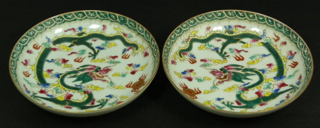 PAIR OF 18th CENTURY FAMILLE ROSE DRAGON DISHES: Pair of antique Chinese Qing Dynasty period hand painted enameled Famille Rose low bowls depicting flying dragons amongst multicolored clouds and flaming dragon jewels. Also has a crashing waves desig