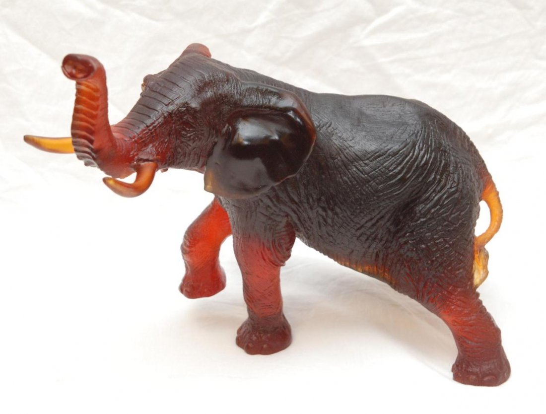 FRENCH DAUM PATE DE VERRE CRYSTAL ELEPHANT FIGURE: French Daum Pâte de Verre amber art glass elephant figure depicted with trunk and right foot raised. Includes original fitted crate. Measures 13 inch height (33 cm) x 17 inch length (43.2 cm).