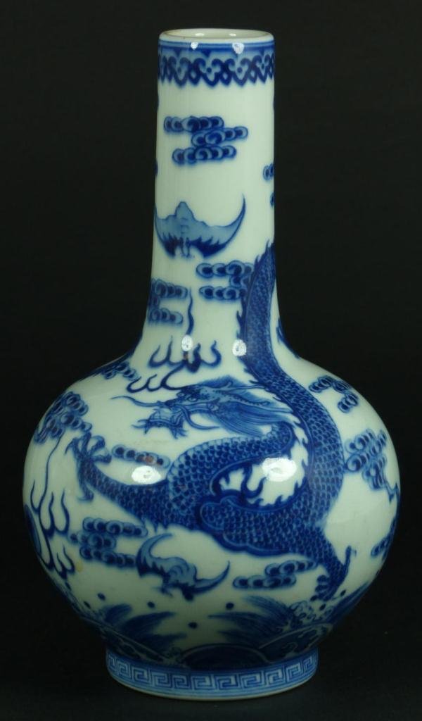 CHINESE BLUE & WHITE PORCELAIN DRAGON VASE: A Chinese blue & white porcelain bottle form vase. Depicts dragons and dragon jewels with bats over crashing waves. Holds six character blue archaic Qing Dynasty Qianlong period reign mark. Measures 7