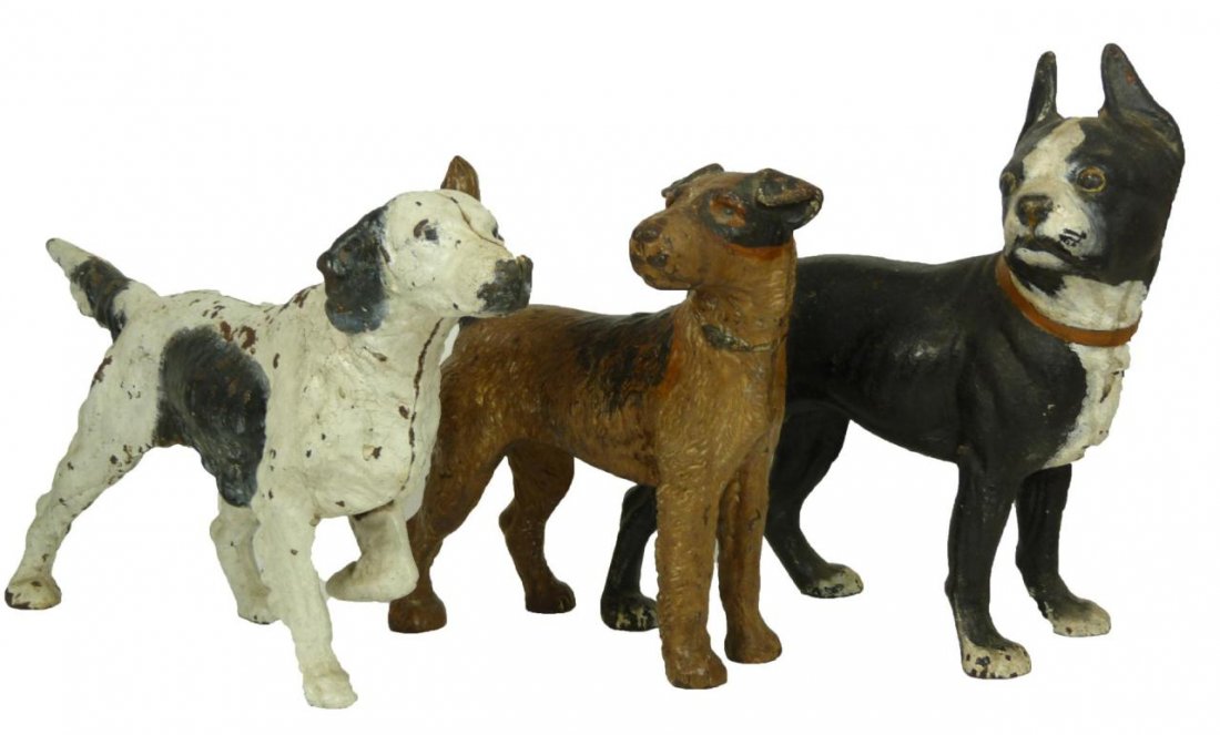 3 CAST IRON FIGURAL DOG DOORSTOPS: Lot of three cast iron figural dog doorstops including a Boston Terrier, a Fox Terrier, and an English Setter. Late 19th early 20th Century. Tallest measures 10 3/8 inch height (26.4 cm). Total weight
