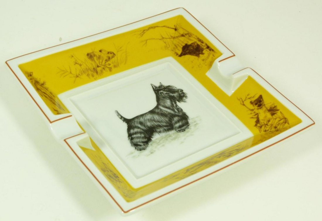 HERMES 'SCOTTISH TERRIER' PORCELAIN ASHTRAY: Hermes French hand painted porcelain ashtray featuring a Scottish Terrier in the center surrounded by game over yellow ground on the border including a badger, rabbit, mink, boar, and fox. Bottom has