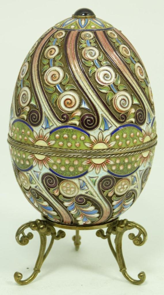 RUSSIAN SILVER ENAMELED AND JEWELED EGG BOX: Russian silver egg box with a multicolor enameled spiral design. Round cabochon ruby set on top. Gold wash interior. Holds double headed eagle mark, 84 silver purity with town mark and Ivan Petrovich 