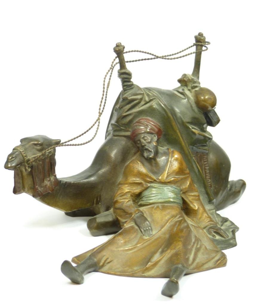 AUSTRIAN COLD PAINTED BRONZE OF BEDOUIN & CAMEL: Austrian cold painted bronze sculpture depicting a man resting against a camel. Marked 'BROMA' to bottom. Circa 1920. Measures 5 3/8" height x 8" width x 7" depth (13.6cm x 20.3cm x 17.8cm). Total wei