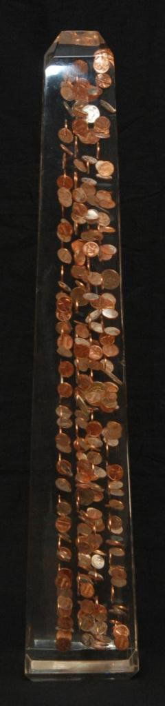 MODERN LUCITE 'FLOATING COIN' OBELISK SCULPTURE: Modern lucite 'Floating Coin' obelisk sculpture. Lucite body with American coins inside. Measures 30" height x 5 1/2" width x 5 1/4" depth (76.2cm x 13.9cm x 13.3cm).