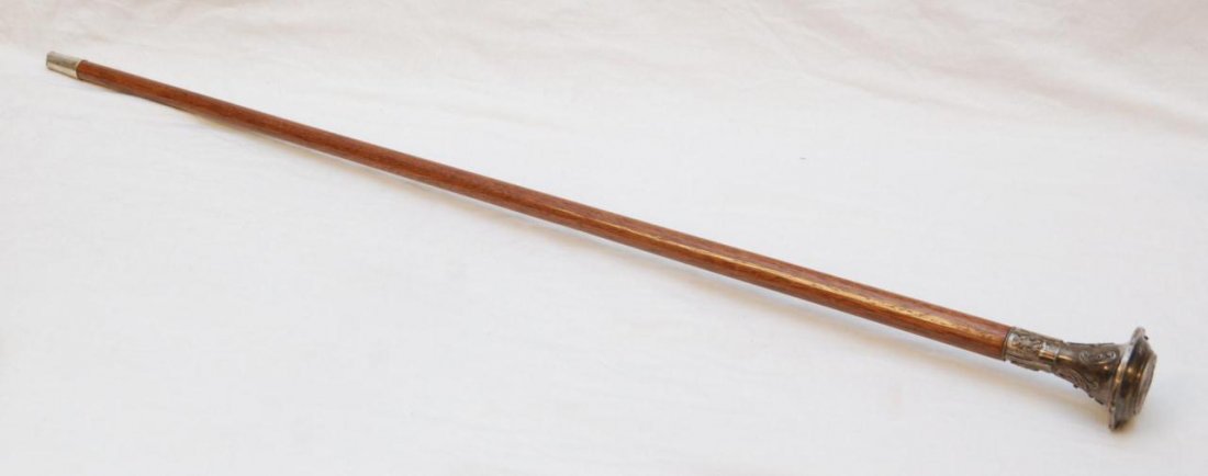 RUSSIAN SILVER CANE WITH TIFFANY MOVEMENT: Russian silver Tiffany & Co. watch cane with raised scrolled design on handle. Tiffany & Co. watch set inside of hinged compartment on handle. Top of handle has inset coin depicting Nicholas II. Holds