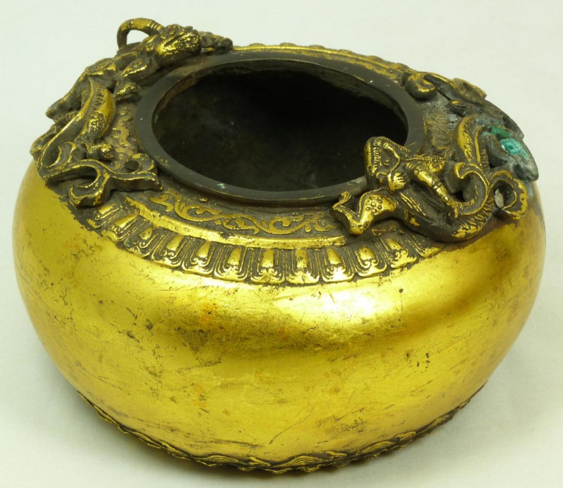 ANTIQUE CHINESE JUNOESQUE COPPER BEAST CENSOR: Antique Chinese junoesque gilded copper censor with a raised Chih Lung dragon design, paddle leaf and scrolled rim design, and has rounded tapered shape ending with crashing waves and paddle fan borde