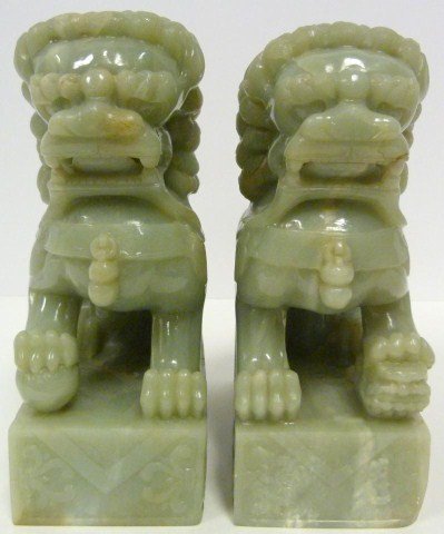 PAIR OF MING DYNASTY CELADON JADE FOO DOGS: Pair of Ming Dynasty hand carved Foo dog figures. Finely carved and heavy. Relief carved scroll and pattern design to base. Measures 8 1/2" height (21.5cm).