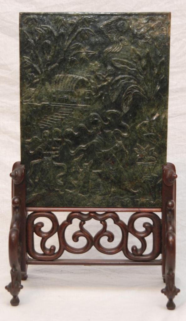 CHINESE HIGH RELIEF SPINACH JADE TABLE SCREEN: Dark mottled jade with high relief carving on one side of a beauty seated on a garden stool. Her attendant by a pavilion in landscape. The reverse carved with a traveler on horseback in landscape. Fit