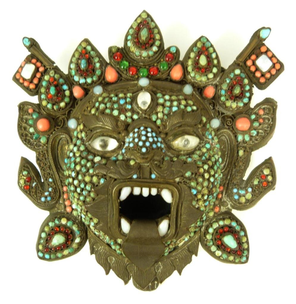 ANTIQUE TIBETAN TURQUOISE AND CORAL BEADED MASK: Antique Tibetan beaded mask vessel. He is growling ferociously and his mouth creates the opening to the interior chamber. To his back flags on poles can be seen. Has filigree work and turquoise, red c