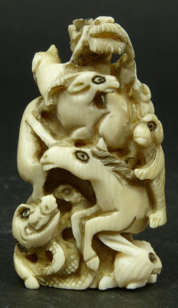 JAPANESE CARVED IVORY ZODIAC NETSUKE: Japanese relief carved netsuke depicting the 12 animals of the zodiac. Signed to bottom. 1 /14in Height. Weighs 31g