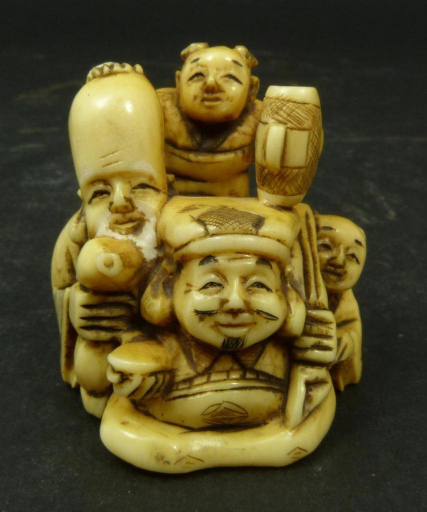 JAPANESE CARVED IVORY NETSUKE GROUP: Japanese carved ivory Netsuke figure depicting Shou Zing with immortal and two attendants. 19th/20th century. Etched calligraphy sign to bottom. 1 5/8in Height. Weighs 39g,