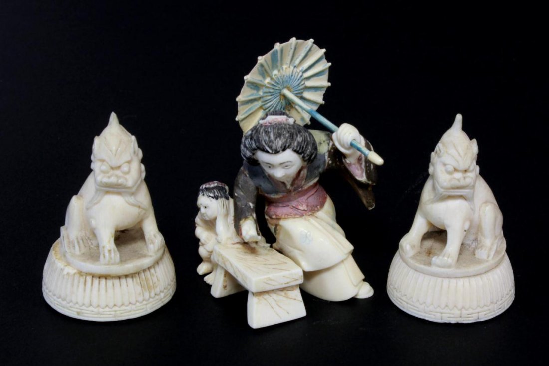 3 JAPANESE CARVED IVORY STUDIES: Lot of three Japanese hand carved ivory studies including a polychromed seated maiden with child and umbrella netsuke and a pair of foo dog seals. 19th/20th century. Tallest piece measures approx. 2 5