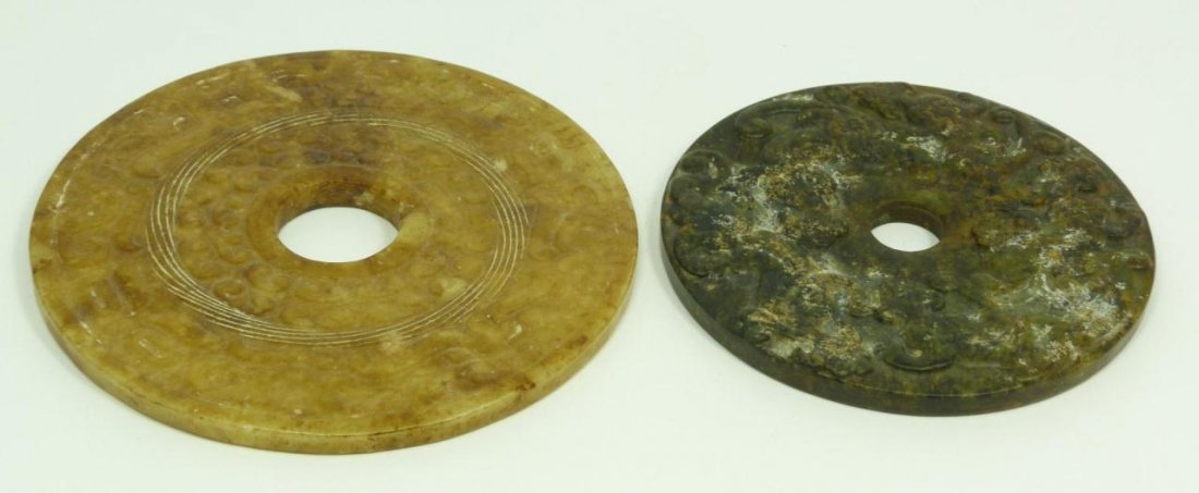 TWO CHINESE HAN DYN. STYLE CARVED JADE BI DISCS: Lot of two Chinese Han Dynasty style carved Jade bi discs; One dark green bi carved with dragon & phoenix motif on front and scrolling clouds on the reverse, measures 3 7/8" diameter (9.82cm). The oth