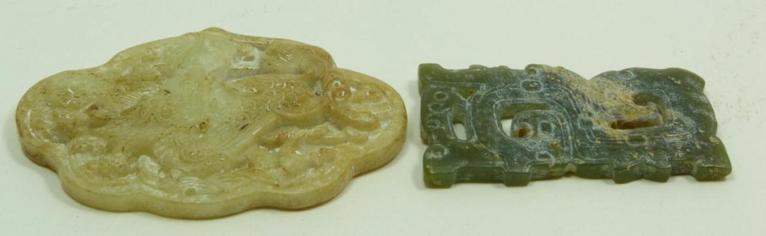 TWO CHINESE CARVED JADE PLAQUE PENDANTS: One Chinese white Jade pendant, carved in the Warring States style with dragon and sacred pearl motif, highly translucent, measures 3 3/16" (8.07cm). The other, a Chinese Qing Dynasty green Jade penda
