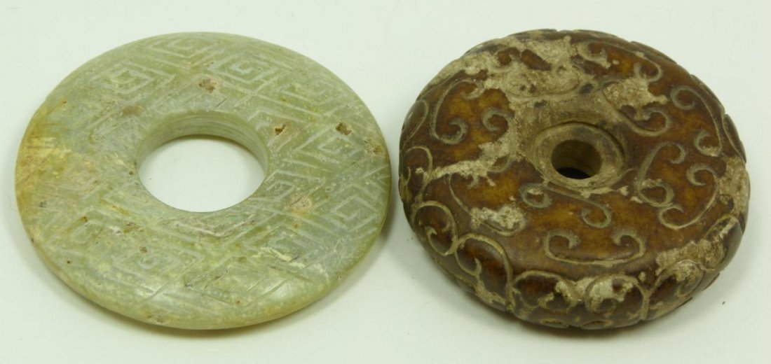 CHINESE CARVED HARDSTONE & JADE BI DISCS: One Chinese light green Jade bi, carved throughout with geometric pattern in the Shang Dynasty style, reported origin of Yellow River Valley, low level of calcification, measures 2 7/16" diameter (6.1
