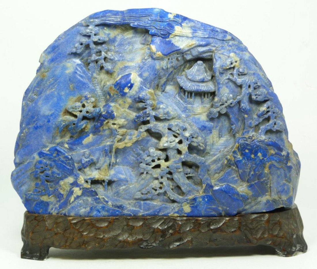 A CHINESE RELIEF CARVED LAPIS LAZULI BOULDER: Old Chinese high relief carved lapis lazuli carved boulder with landscape mountain scene with traveling wise man and attendant crossing a bridge on a trail leading towards pagodas. Flowing water and t