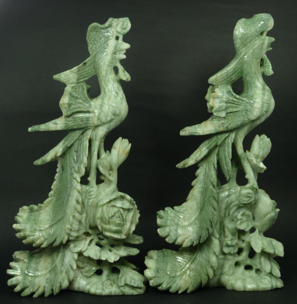 A PAIR OF CHINESE SOAPSTONE PHOENIX BIRDS: A pair of large Chinese soapstone phoenix bird figures. Each depicted perched on a branch with leaves and flowers. Figures measure 15 1/8" height (38.4cm). Total weight of 5.94 kilograms.