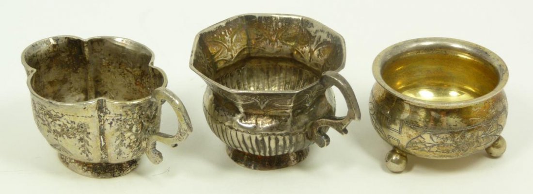 A GROUP OF 3 RUSSIAN SILVER TABLE ITEMS: A group of three Russian silver table items, including two demitasse cups and a footed salt cellar. Each holding impressed marks to bottom. Tallest measures 1 5/8" height (4.1cm). Total weight of 3.18
