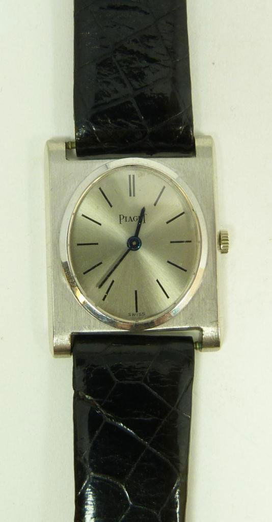18K WG PIAGET WATCH w BLACK LIZARD LEATHER BAND: Ladies 18k white gold Piaget watch black lizard band. White gold tone face with black enamel notches. Metallic cobalt hour and minute hands. Face marked 'PIAGET SWISS'. White gold buckle, fully hallma