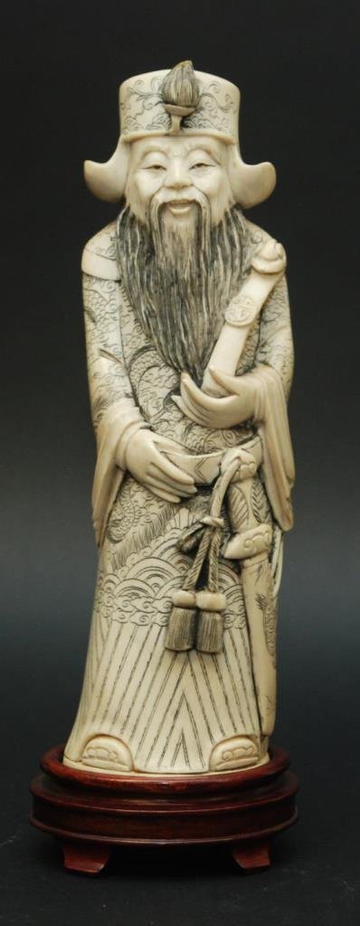 CHINESE CARVED AFRICAN IVORY EMPEROR FIGURE: Chinese hand carved African ivory figure depicting a standing emperor wearing Imperial robe with etched dragon design. He is depicted holding a ruyi scepter to left hand. Includes fitted wooden base. 