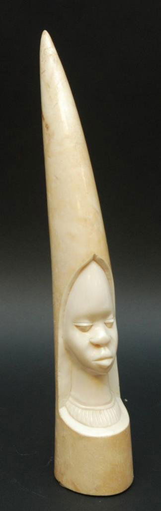 AFRICAN IVORY TUSK DEPICTING TRIBAL MAN: African ivory tusk depicting the bust of a tribal man. Measures 16 1/4" height x 10" girth (41.2 x 25.4cm). Total weight of 1763 grams.