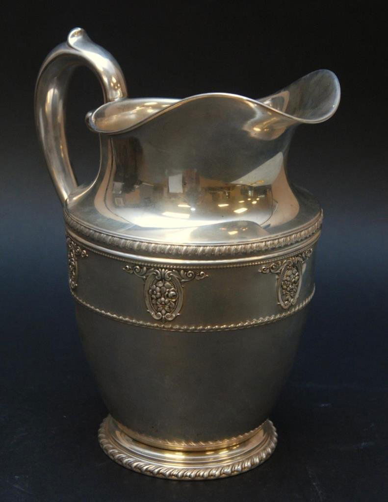 WALLACE ROSEPOINT REPPOUSE STERLING SILVER PITCHER: Wallace American sterling silver repousse pitcher in the 'Rosepoint' pattern. Depicts floral bouquets in scrolled frames. Bottom holds 4640-9 manufacturer's number. Measures 9 3/8" height (23.8cm). To
