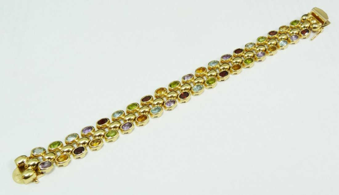 14K YG SEMI PRECIOUS STONE LINK BRACELET: 14k yellow gold link bracelet holding 40 oval cut bezel set semi precious stones approx. 16.0ctw. Marked 14K to clasp with S in circle mark. Patent number 4697315. Measures 7 1/4" length x 5/8" width 