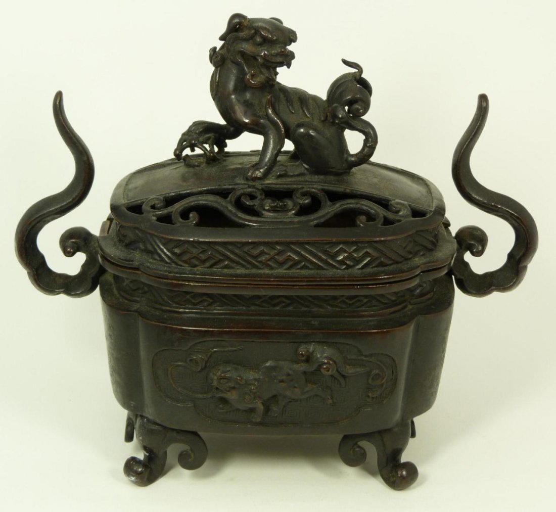 19th CENTURY JAPANESE BRONZE INCENSE BURNER: Antique Japanese incense burner. Raised foo lions to front and back of body. Cover has foo lion finial and scrolled screen design. Rests on four scrolled feet. Late Edo to Meiji period. Measures 9 1/4