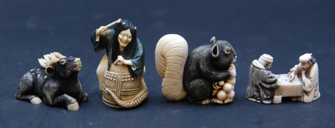 A LOT OF 4 CHINESE CARVED IVORY NETSUKE FIGURES: A lot of four Chinese hand carved African ivory netsuke figures including a recumbent stag, squirrel with peaches, a kabuki theatre player with demon trap and mallet and lastly a group of wise men pla