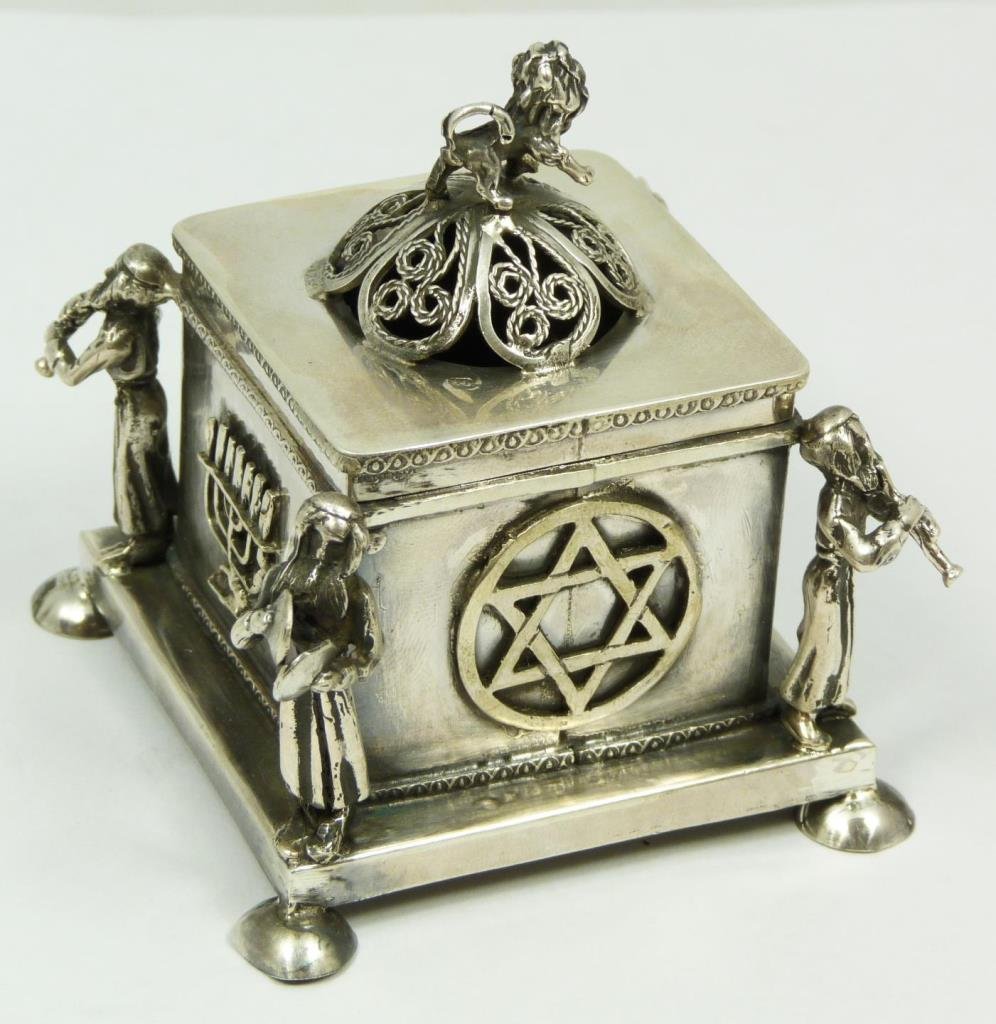 RUSSIAN JUDAIC SILVER COVERED TRINKET BOX: Russian Judaica silver trinket box having lion finial to cover. Corners having figural Hasidic musicians playing horns and cymbals. Applique star of David and Menorah designs to sides. Bottom holds 84