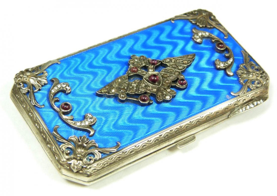 RUSSIAN SILVER ENAMELED CIGARETTE CASE: Russian guilloche enameled silver cigarette case having diamond and ruby jeweled applique double headed eagle and floral scroll design throughout over royal blue guilloche enameled ground. 88 silver p